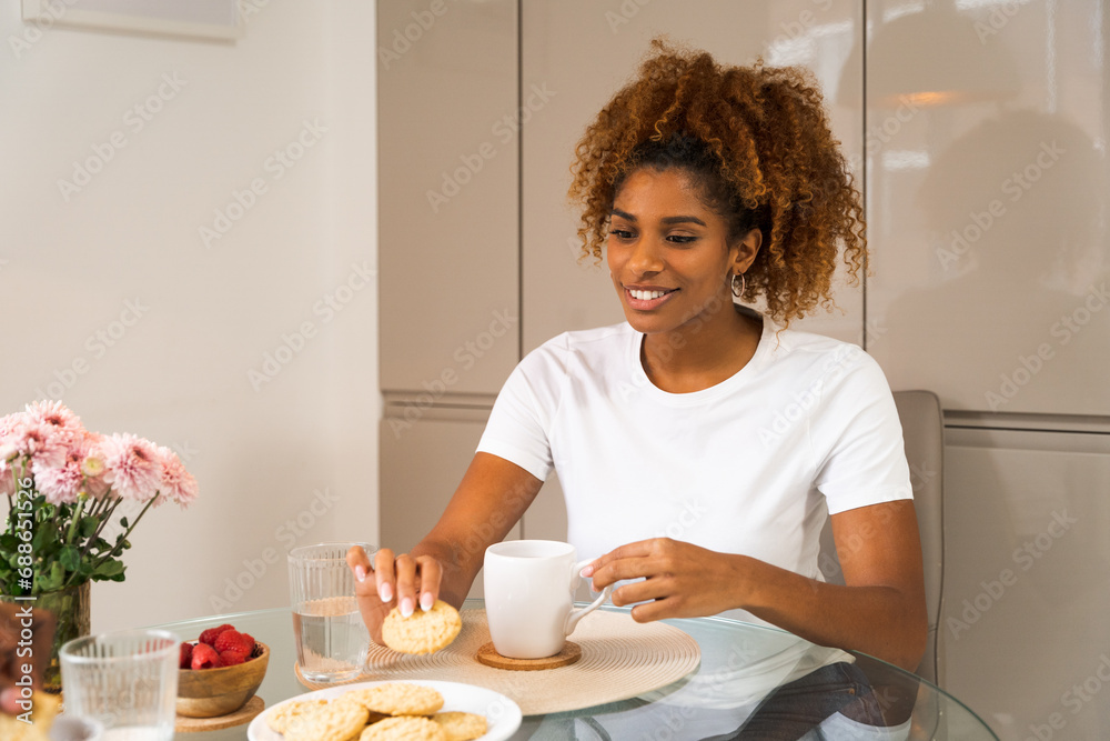 Happy african american woman eating breakfast while sitting at home alone Happy african american woman eating breakfast while sitting at home alone