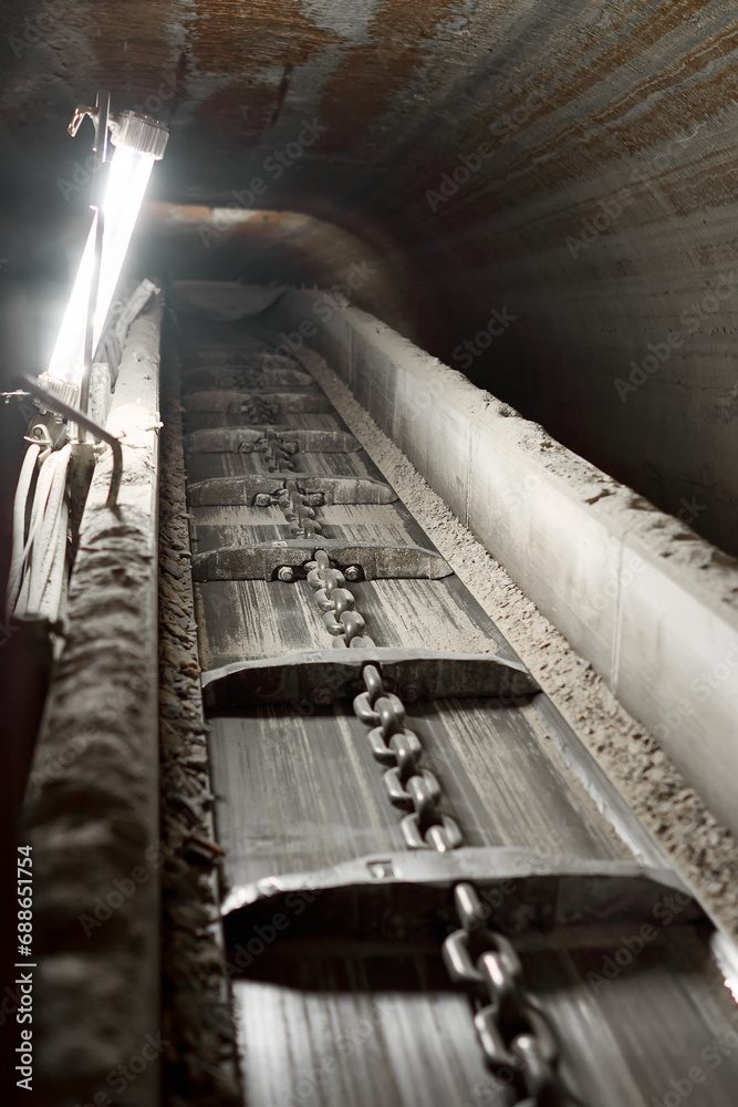 Obraz premium Horizontal photo of a conveyor belt in a mine. Extraction of minerals from the bowels of the earth.