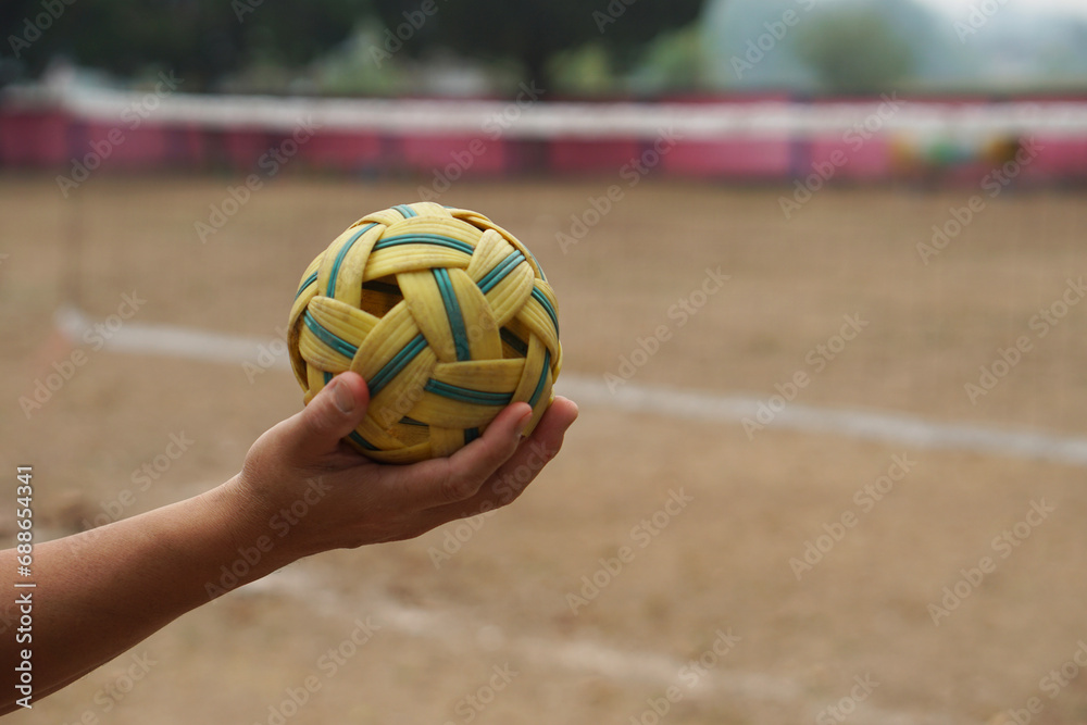Closeup man hold Sepak Takraw ball outdoor. Concept, Asian traditional sport. A ball made of rattan or synthetic plastic. Sport with equipment that can play for outdoor or indoor. Competitive game.   