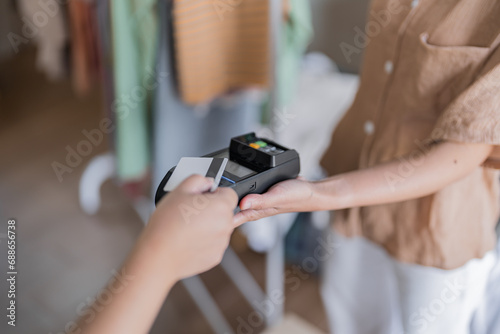 Contactless payment holding credit card with touch settlement paying for shopping nfc technology transaction cashless technology and credit card payment photo