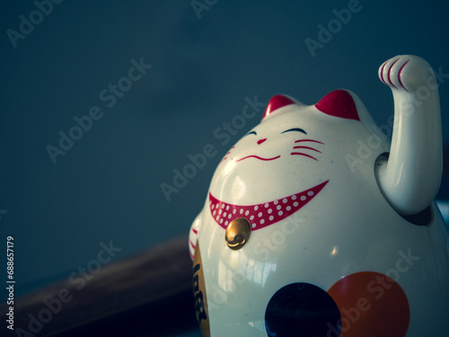 Vieille statue traditionnelle japonaise en céramique et poussiéreuse d'un chat porte-bonheur photo