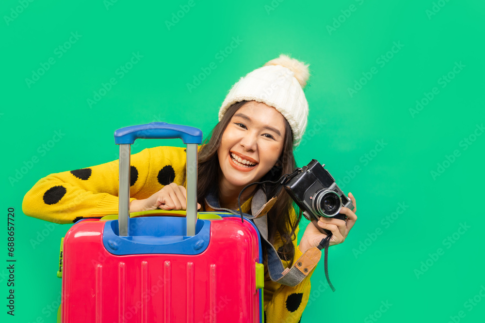 Tourist asian woman in casual clothes hat hold suitcase using mobile cell phone sit isolated on colour background Passenger travel abroad weekends . - obrazy, fototapety, plakaty 