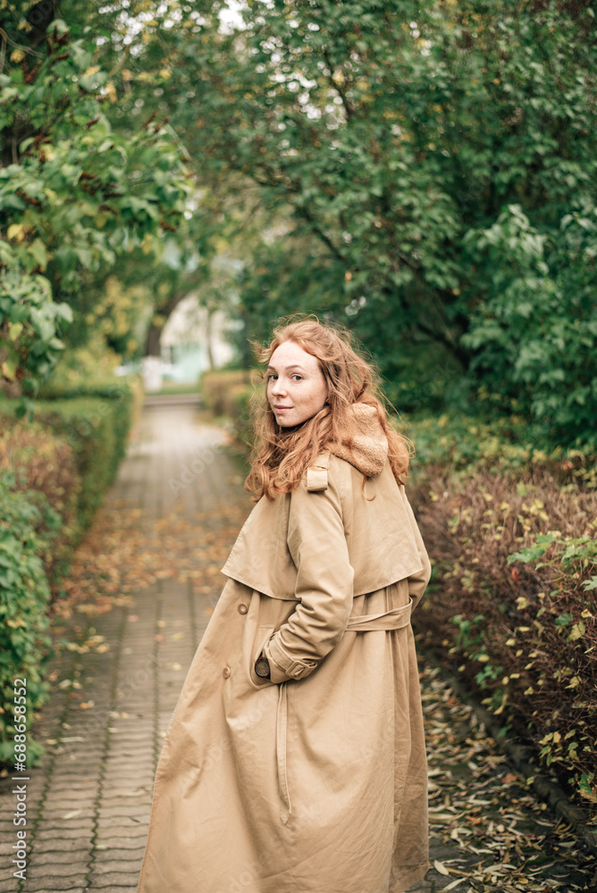 red-haired girl in a beige trench coat in autumn red-haired girl in a beige trench coat in autumn