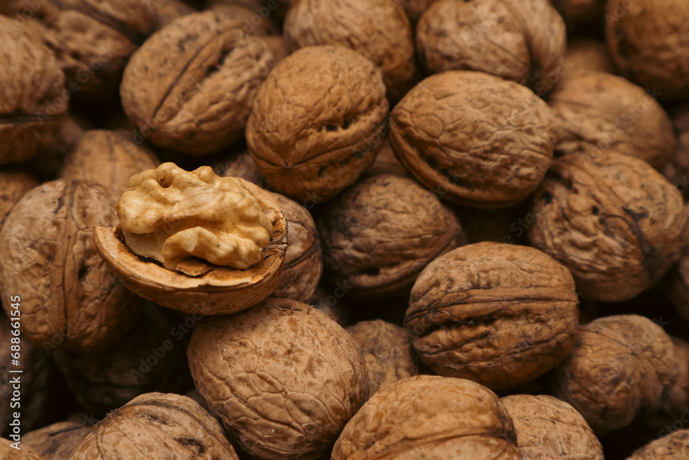 Walnuts in a shell. Background with many walnuts. Ripe walnut sold in the market Walnuts in a shell. Background with many walnuts. Ripe walnut sold in the market