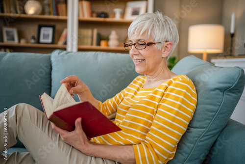 Фотография Senior woman mature caucasian female read book at home wear eyeglasses