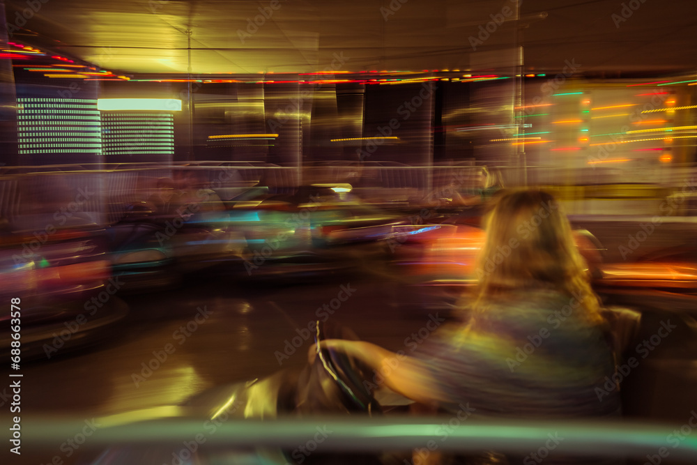 nice colorful abstract, blurred view of a girl driving electrical entertainment bumper car