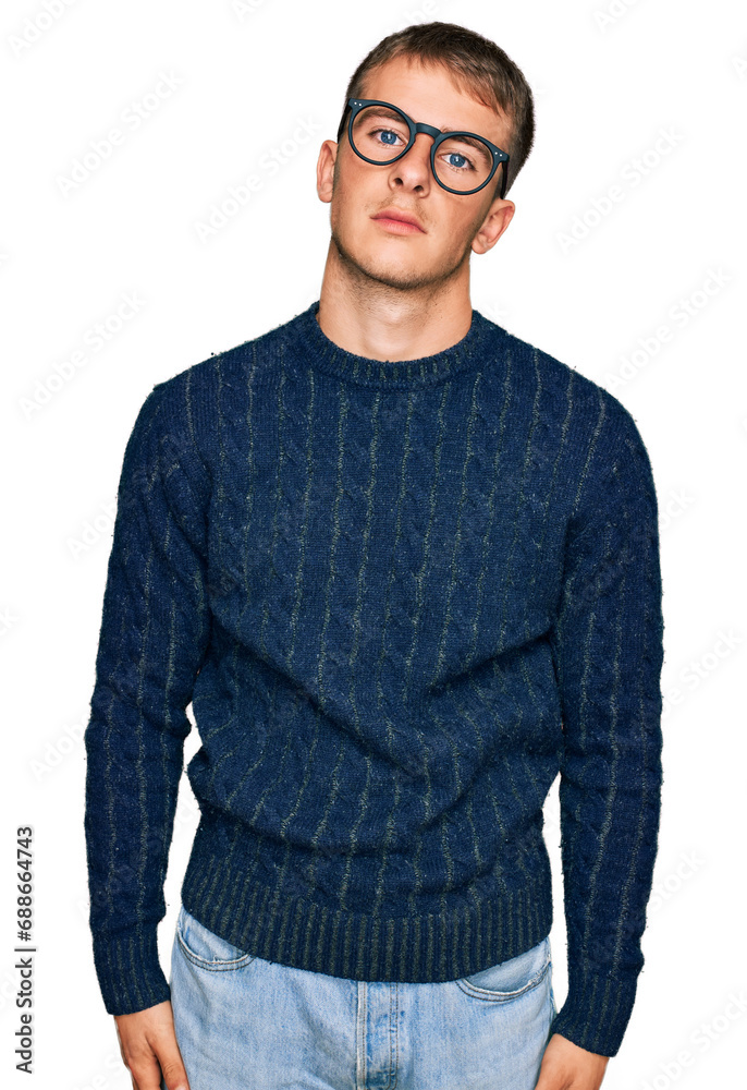 Young blond man wearing casual clothes and glasses relaxed with serious expression on face. simple and natural looking at the camera.