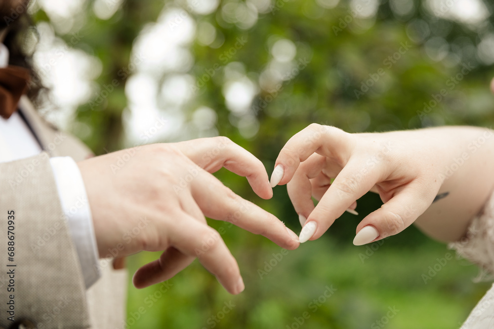 Bräutigam und Braut formen Herz mit ihren Fingern
