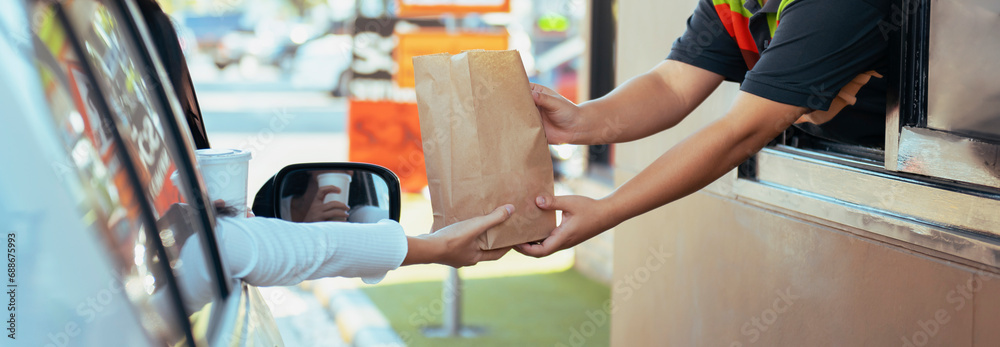 Woman getting fast food at drive-thru - obrazy, fototapety, plakaty 