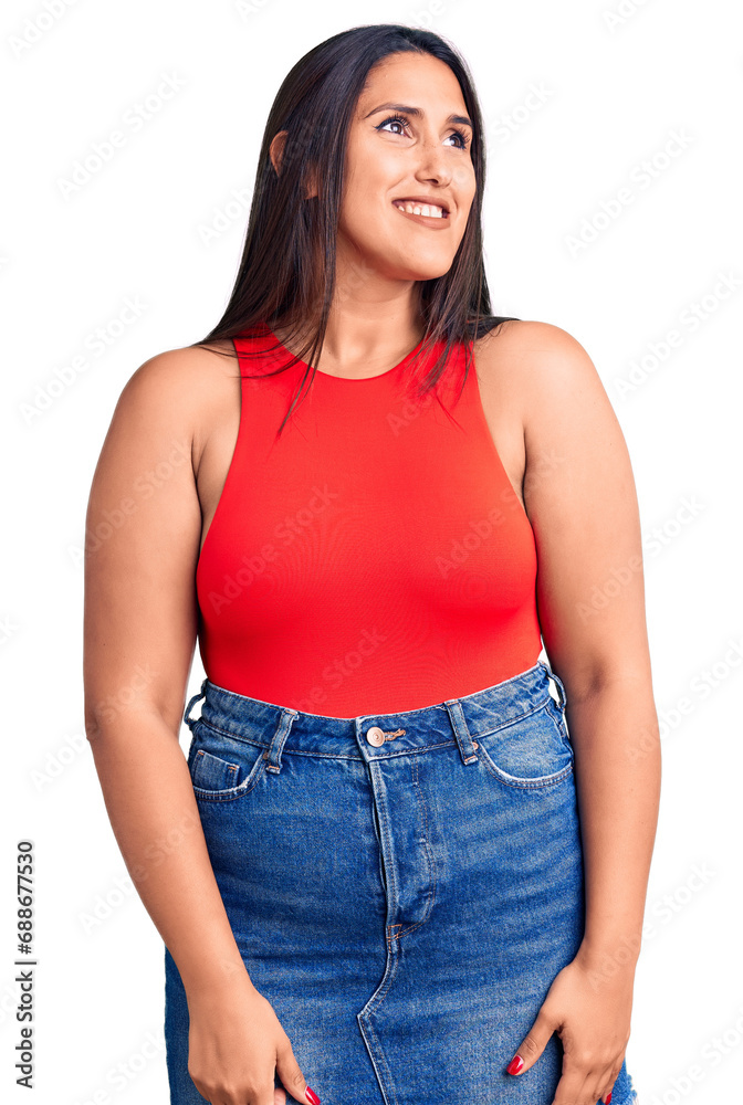 Obraz premium Young beautiful brunette woman wearing casual sleevelss t-shirt looking away to side with smile on face, natural expression. laughing confident.