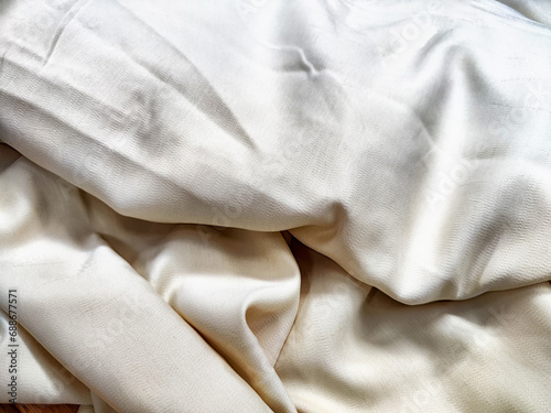Obraz na plátně Folds and waves of wrinkled satin beige or white fabric
