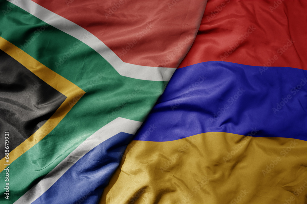 big waving national colorful flag of armenia and national flag of south africa .