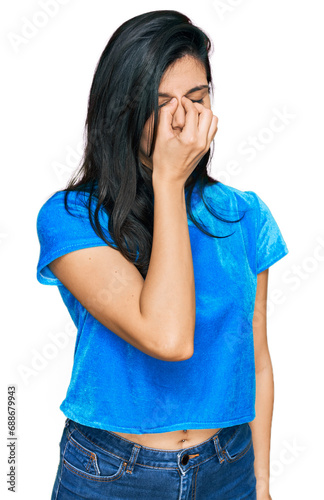 Young hispanic woman wearing casual clothes tired rubbing nose and eyes feeling fatigue and headache. stress and frustration concept.