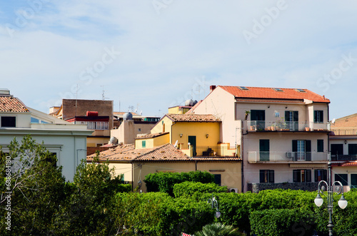 Landscape view of red tile rooftops of colored residential houses against blue sky. Typical architecture of city in Sicily. Santo Stefano di Camastra  Italy. Travel and tourism concept