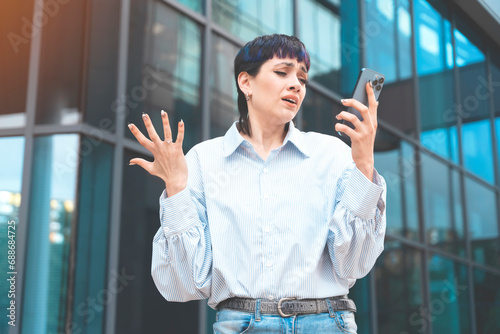 Portrait of a young woman talking in anger on her mobile to her boyfriend about ending their relationship toned image