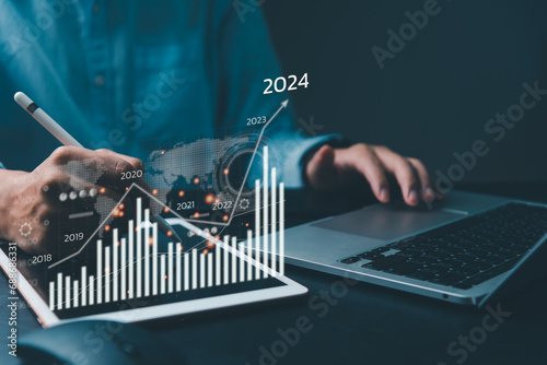 financial charts and graph analysis marketing showing growing revenue In 2024 floating above digital screen tablet, business about strategy for growth and success. photo