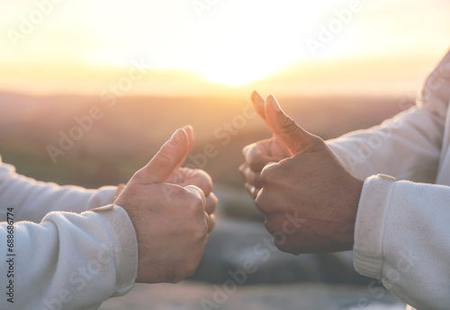 Two men giving thumb up to each other at sunset nature background. Power of teamwork and frienship concept toned image photo