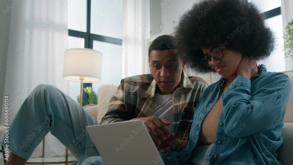 Sad stressed African woman laptop problem virus spam broken computer at home man trying help couple trouble online disagreement using internet together pc failure family stress shopping disconnect