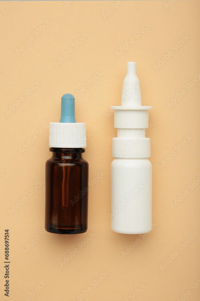 Bottles of nasal drops on beige background. Vertical photo Bottles of nasal drops on beige background. Vertical photo