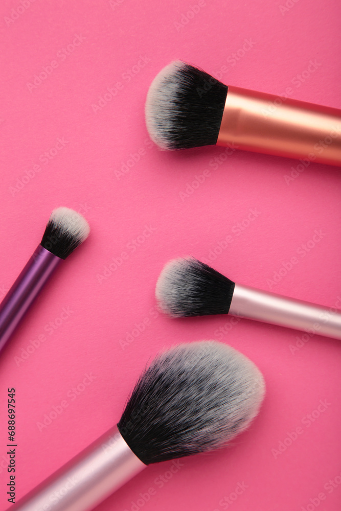 Professional female cosmetics brushes for makeup and eyelash brush on pink background. Cosmetics concept, make up concept Professional female cosmetics brushes for makeup and eyelash brush on pink background. Cosmetics concept, make up concept