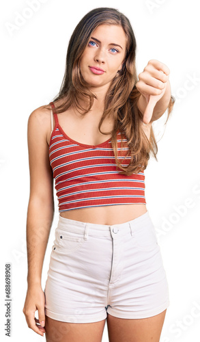 Beautiful caucasian young woman wearing casual clothes looking unhappy and angry showing rejection and negative with thumbs down gesture. bad expression.
