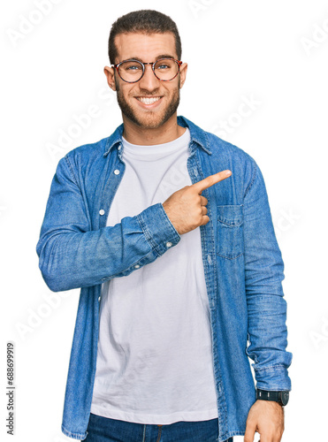 Young caucasian man wearing casual clothes pointing aside worried and nervous with forefinger, concerned and surprised expression