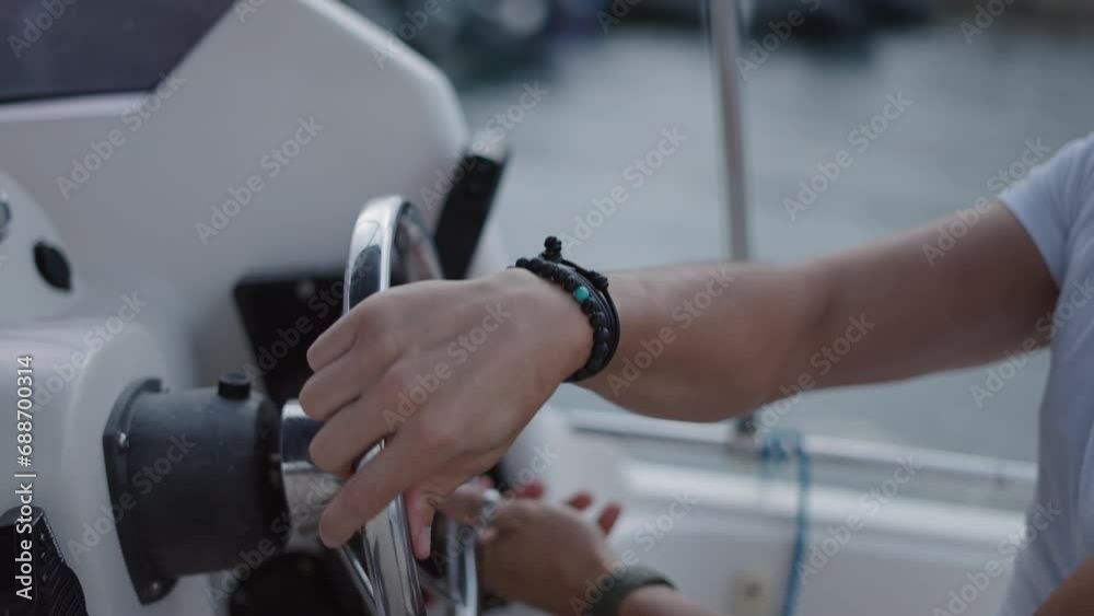 Man hands turning the steering wheel of a boat Man hands turning the steering wheel of a boat