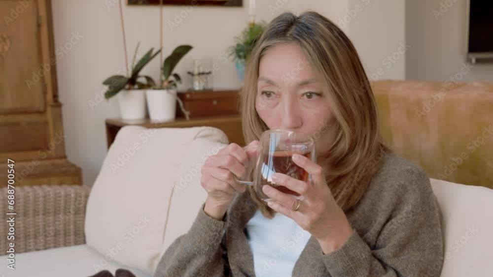 Asian woman spending great time at home drinking coffee, hot chocolate, tea, listening to music, communicating with family. Lifestyle concept Asian woman spending great time at home drinking coffee, hot chocolate, tea, listening to music, communicating with family. Lifestyle concept