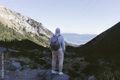 A tourist stands on the peak of a mountain.