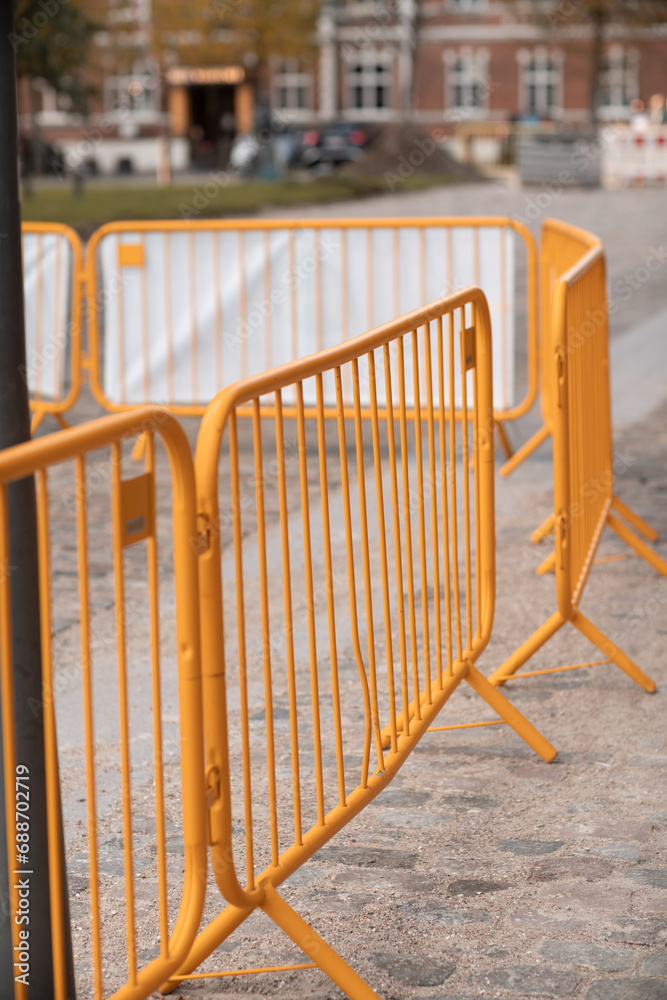 Yellow construction workers fence around pavers working in old part of urban area. Yellow construction workers fence around pavers working in old part of urban area.