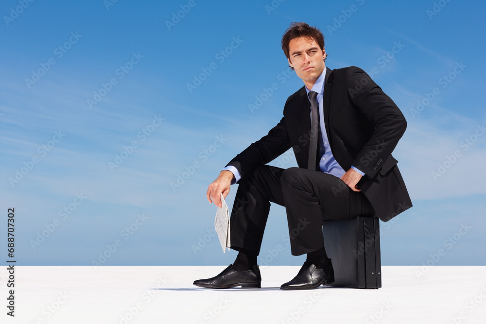 Thinking, sky and a business man on a briefcase with a newspaper for planning or company vision outdoor. Idea, future and space with a young corporate employee in a suit, sitting on a bag in summer Thinking, sky and a business man on a briefcase with a newspaper for planning or company vision outdoor. Idea, future and space with a young corporate employee in a suit, sitting on a bag in summer