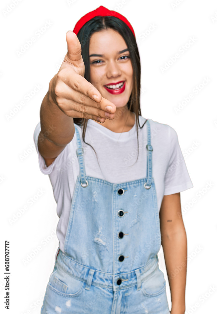 Young hispanic girl wearing casual clothes smiling friendly offering handshake as greeting and welcoming. successful business. Young hispanic girl wearing casual clothes smiling friendly offering handshake as greeting and welcoming. successful business.