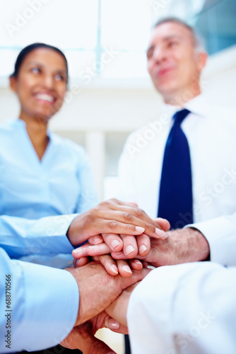Business people, hands together and meeting in teamwork for motivation, unity or collaboration at office. Group of employees piling for building, diversity or support in community trust at workplace
