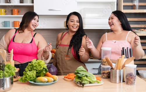 Happy three Asia plus size woman prepare cooking vegetables salad in kitchen at home 