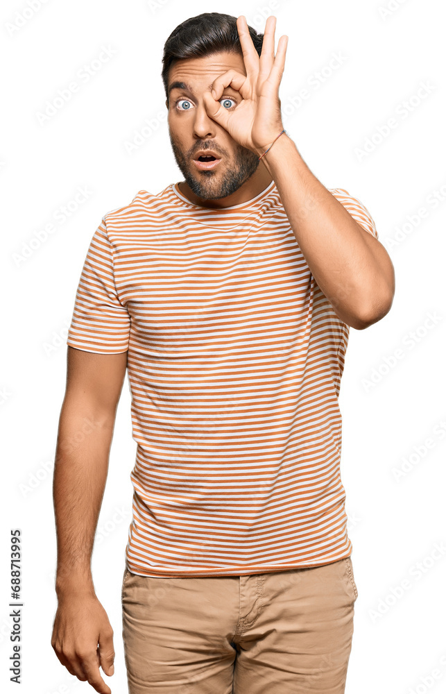 Handsome hispanic man wearing casual clothes doing ok gesture shocked with surprised face, eye looking through fingers. unbelieving expression. Handsome hispanic man wearing casual clothes doing ok gesture shocked with surprised face, eye looking through fingers. unbelieving expression.