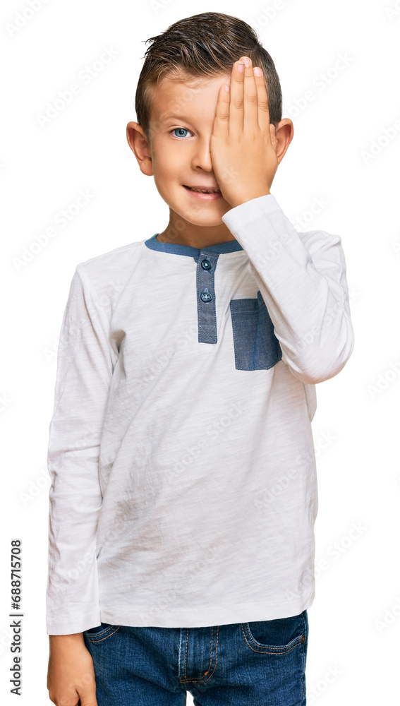 Adorable caucasian kid wearing casual clothes covering one eye with hand, confident smile on face and surprise emotion. Adorable caucasian kid wearing casual clothes covering one eye with hand, confident smile on face and surprise emotion.