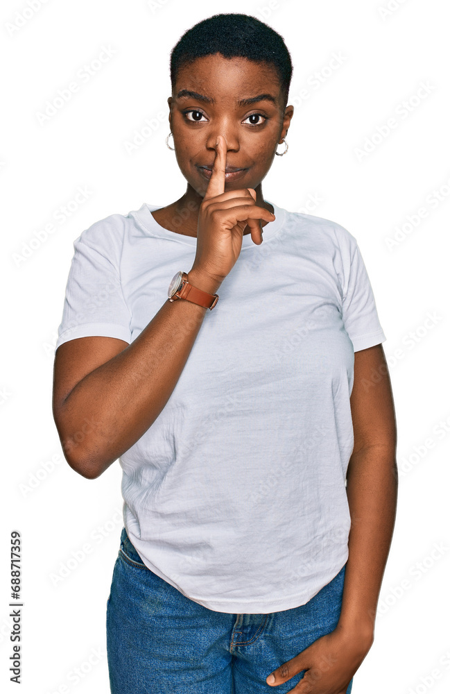 Young african american woman wearing casual white t shirt asking to be quiet with finger on lips. silence and secret concept. Young african american woman wearing casual white t shirt asking to be quiet with finger on lips. silence and secret concept.