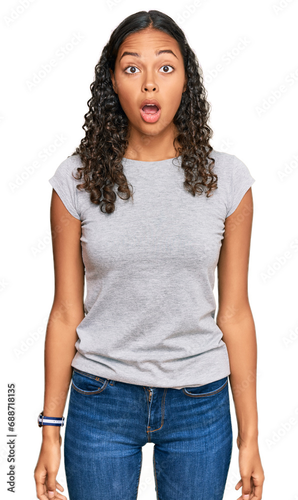 Young african american girl wearing casual clothes afraid and shocked with surprise and amazed expression, fear and excited face. Young african american girl wearing casual clothes afraid and shocked with surprise and amazed expression, fear and excited face.