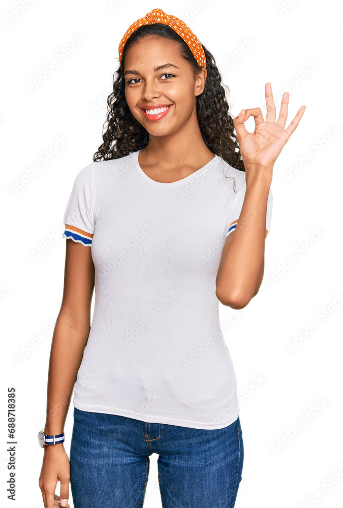 Young african american girl wearing casual clothes smiling positive doing ok sign with hand and fingers. successful expression. Young african american girl wearing casual clothes smiling positive doing ok sign with hand and fingers. successful expression.