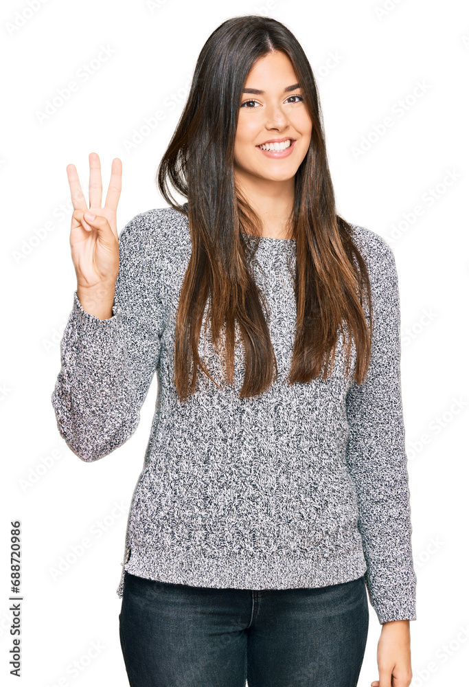 Young brunette woman wearing casual winter sweater showing and pointing up with fingers number three while smiling confident and happy. Young brunette woman wearing casual winter sweater showing and pointing up with fingers number three while smiling confident and happy.