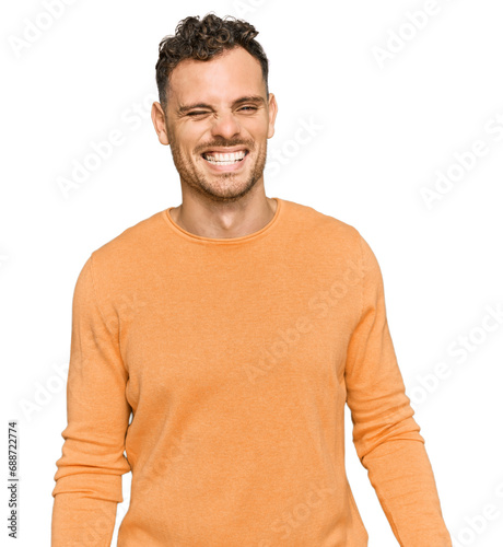 Young hispanic man wearing casual clothes winking looking at the camera with sexy expression, cheerful and happy face. © Krakenimages.com