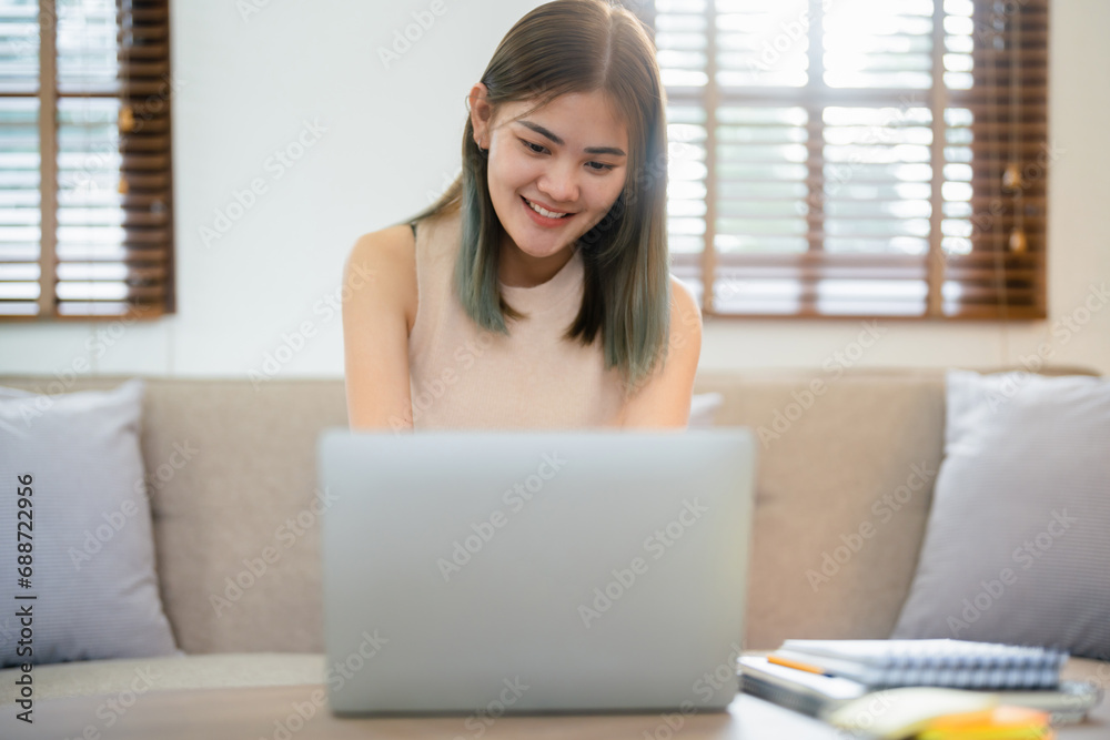 Creative designer woman sitting on sofa and working about graphic design on laptop in home studio Creative designer woman sitting on sofa and working about graphic design on laptop in home studio