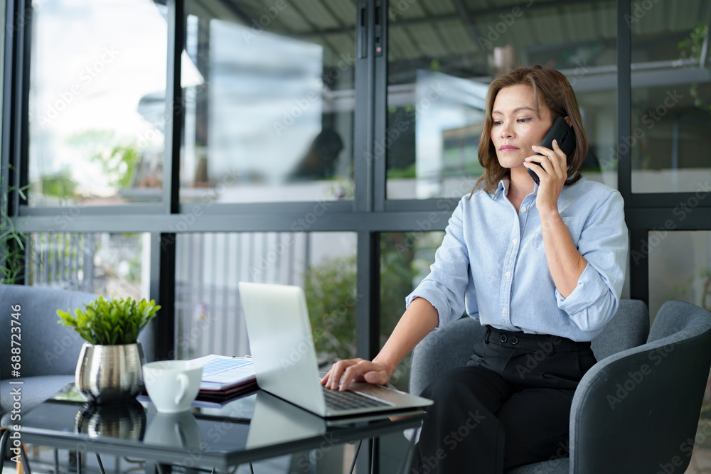 Portrait of middle age asian developer sitting on desk at contemporary office. Portrait of middle age asian developer sitting on desk at contemporary office.