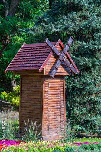 A small wooden decorative mill to decorate city park in Kyiv, Ukraine, closeup. Ecology and environment concept © OlegD