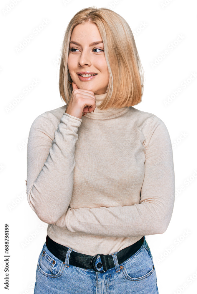 Young blonde woman wearing casual clothes with hand on chin thinking about question, pensive expression. smiling with thoughtful face. doubt concept. Young blonde woman wearing casual clothes with hand on chin thinking about question, pensive expression. smiling with thoughtful face. doubt concept.