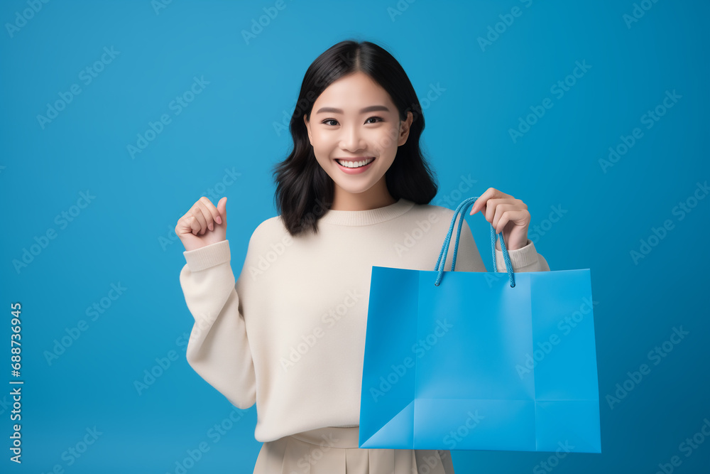 Asian woman shopping bag mockup isolated on a blue background (generative ai) Asian woman shopping bag mockup isolated on a blue background (generative ai)