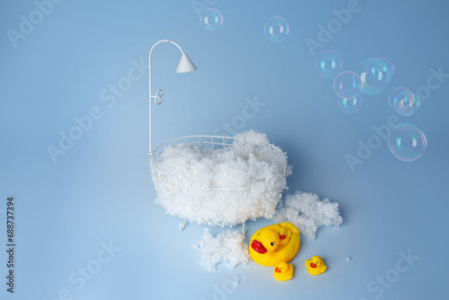 children's holiday decoration of the photo zone. small baby bath with foam and rubber duckies. background texture the first photo session of a newborn photo