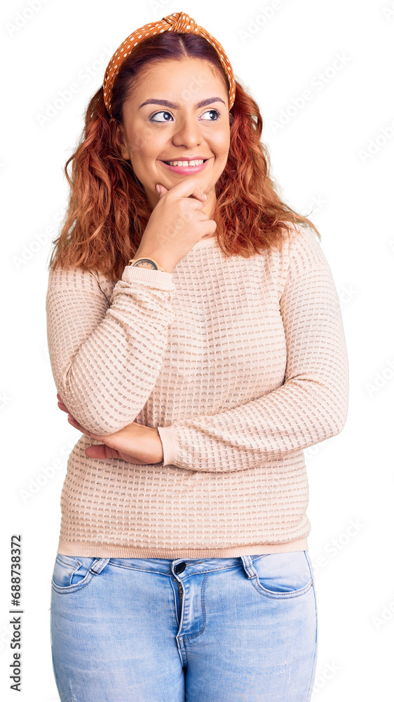 Young latin woman wearing casual clothes and diadem with hand on chin thinking about question, pensive expression. smiling with thoughtful face. doubt concept. Young latin woman wearing casual clothes and diadem with hand on chin thinking about question, pensive expression. smiling with thoughtful face. doubt concept.