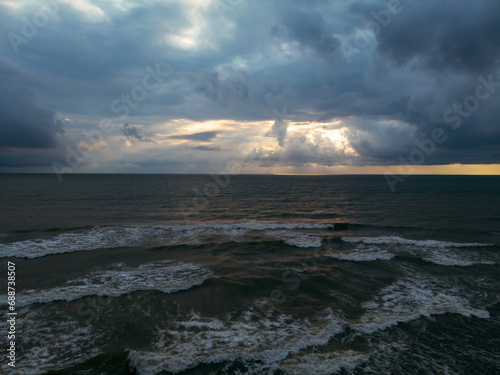 Drone aerial view of the beach with black magnetic sands in Georgia. Storm waves  garbage on the Ureki beach after bad weather  no swimming. Danger on the water for vacationers. Cumulonimbus.