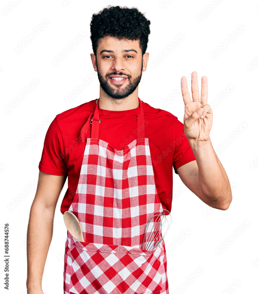 Young arab man with beard wearing cook apron showing and pointing up with fingers number three while smiling confident and happy. Young arab man with beard wearing cook apron showing and pointing up with fingers number three while smiling confident and happy.